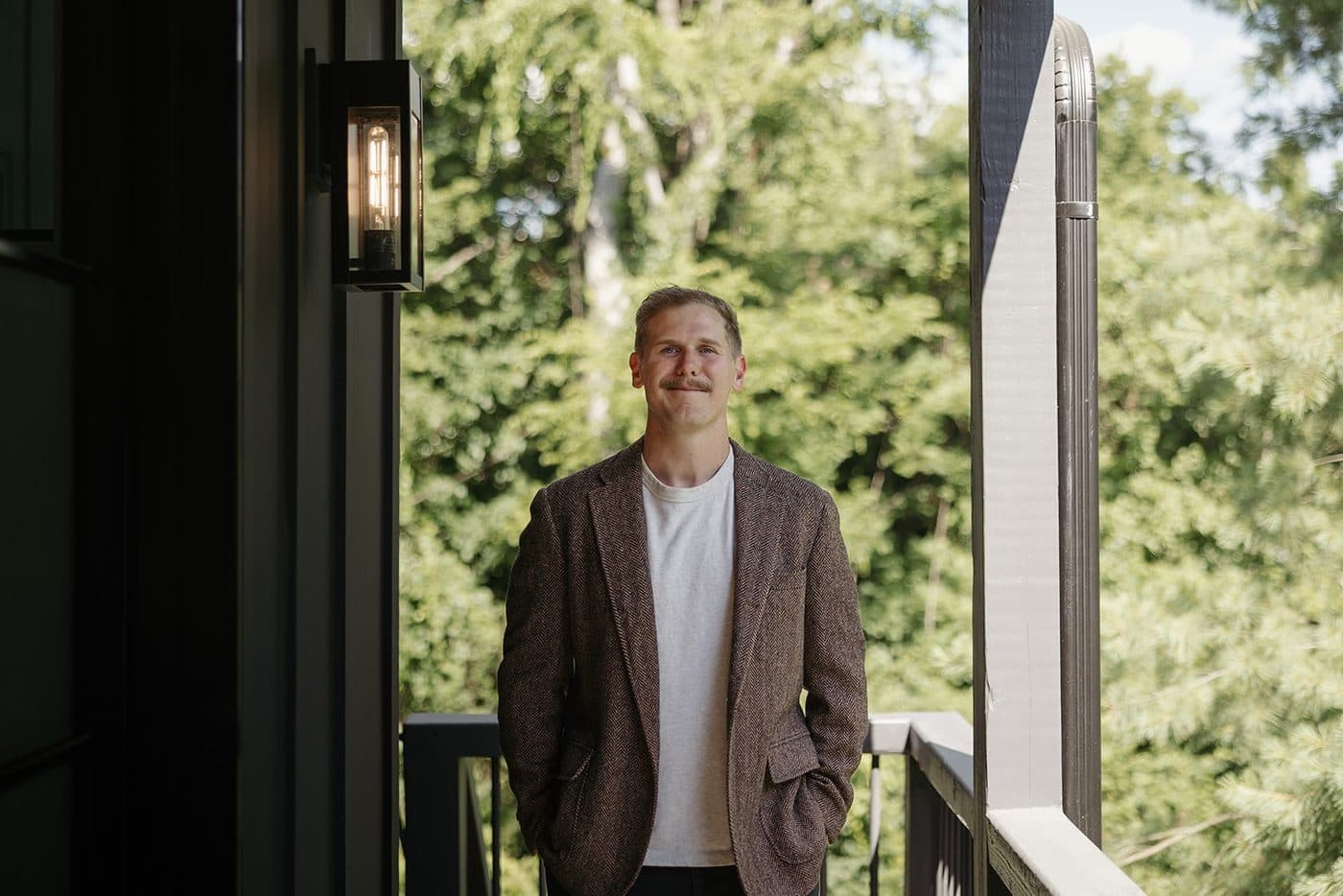 Ryan Boggs on the porch of a Williamson County listing with trees behind