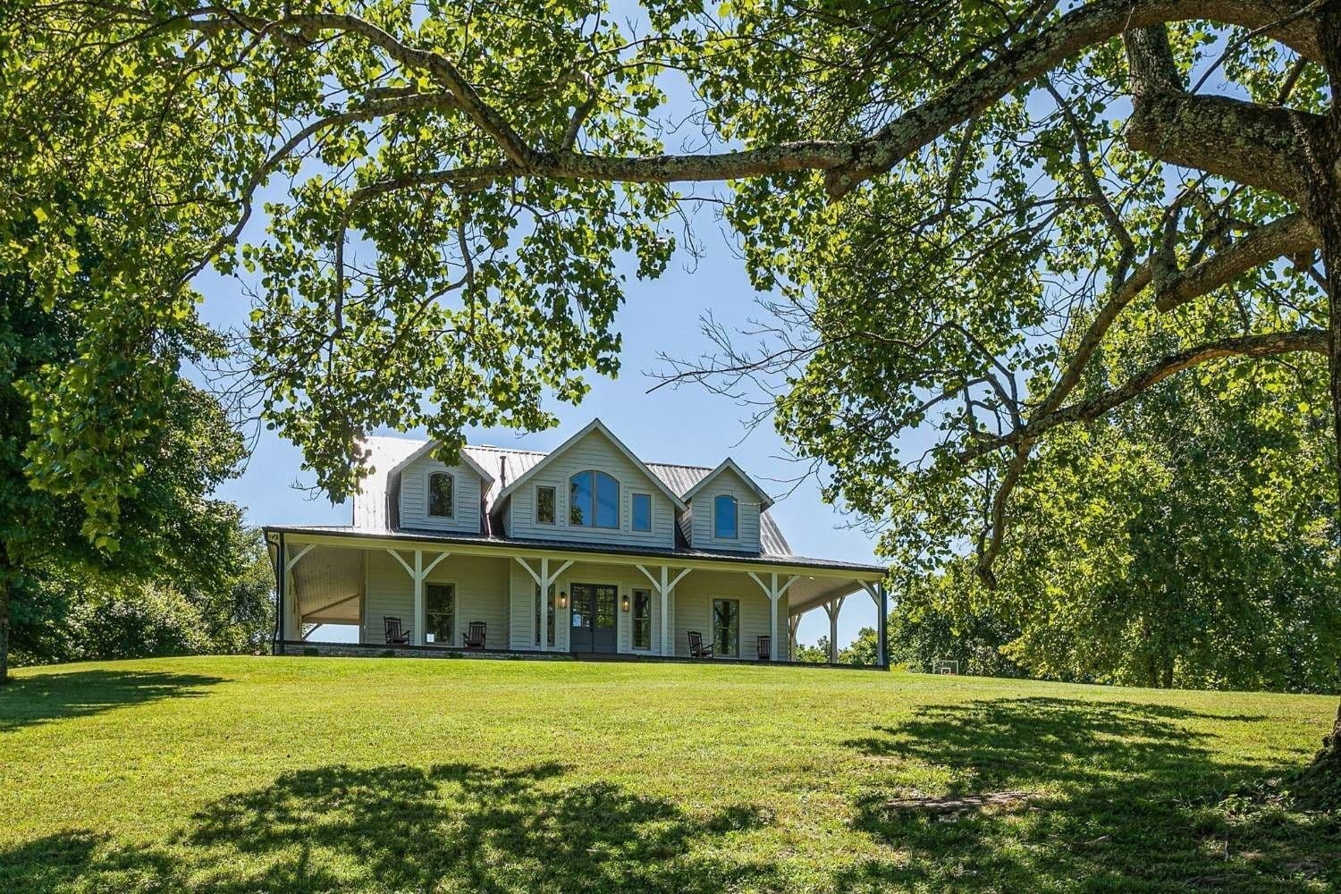White farmhouse estate framed by mature trees on Williamson County acreage