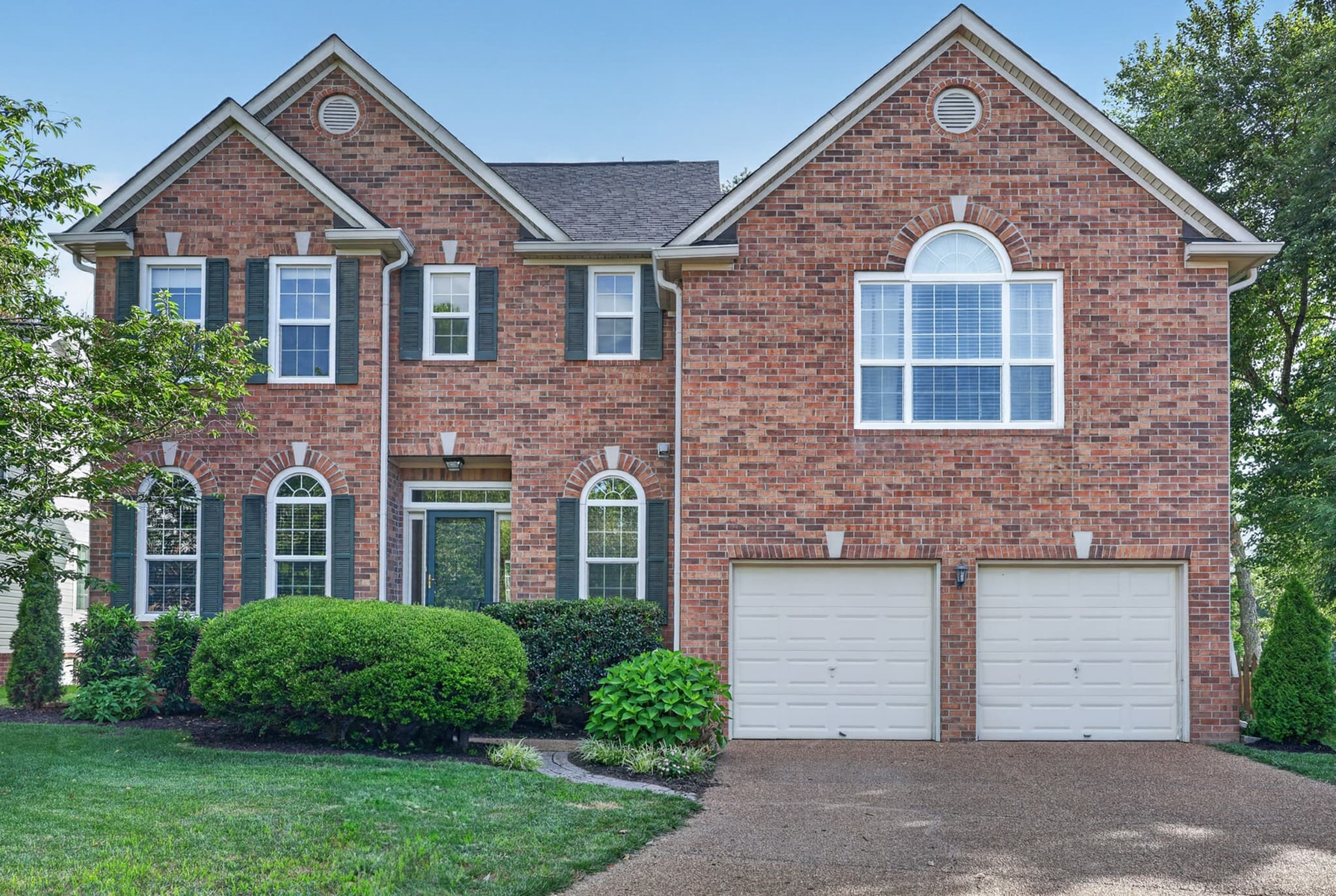 Sold: red brick two-story home with arched windows and dark green shutters in Franklin